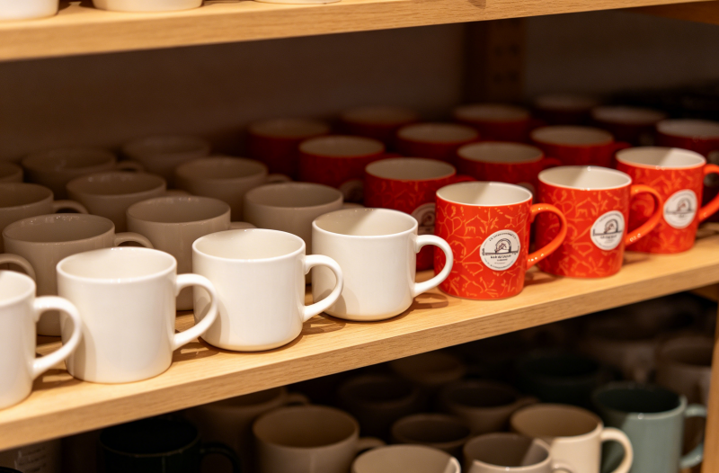 colorful ceramic mugs with different designs a variety of colorful ceramic mugs on a shelf