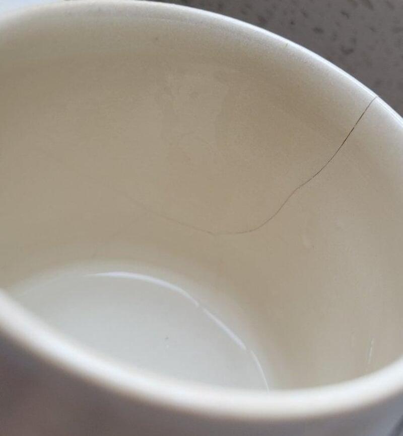Cracked Ceramic Mug Safety White ceramic mug with visible crack showing potential safety risk
